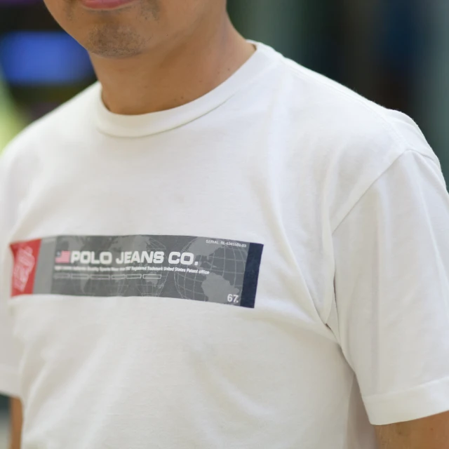 a man is smiling wearing a white tee - shirt with red black and white designs