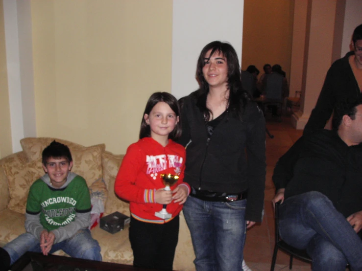 a family sits on a couch while holding drinks