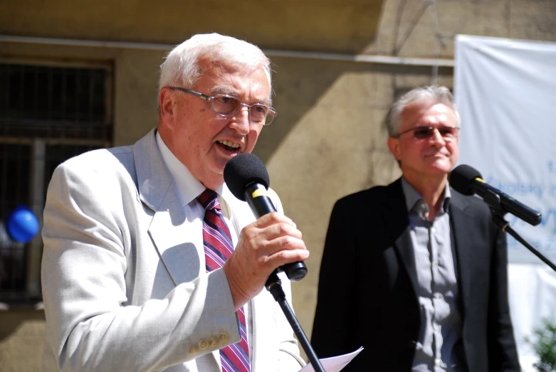 a man in suit and tie giving a speech