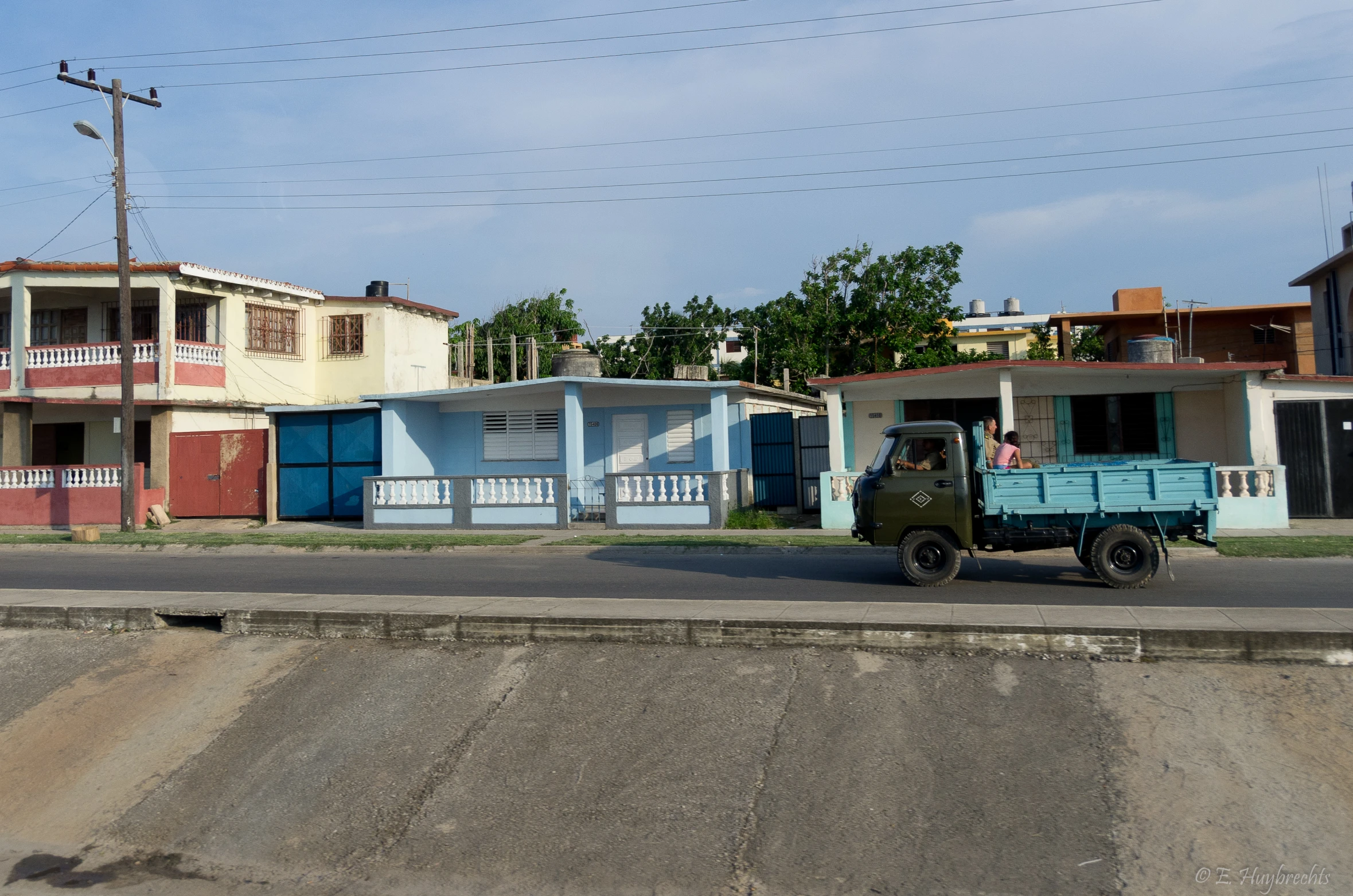 an old truck driving through a neighborhood