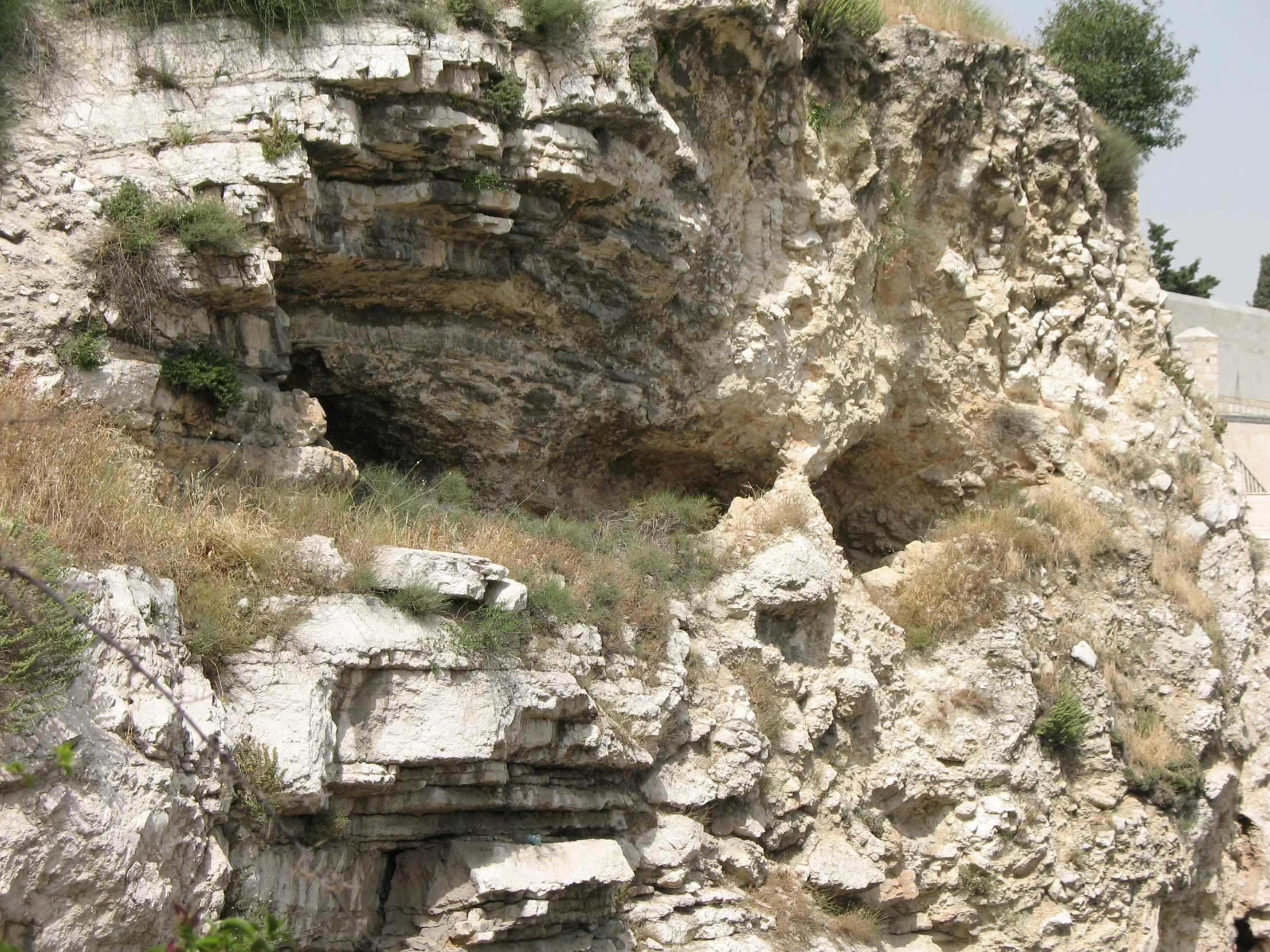 a rocky cliff area with a very large hole in the middle