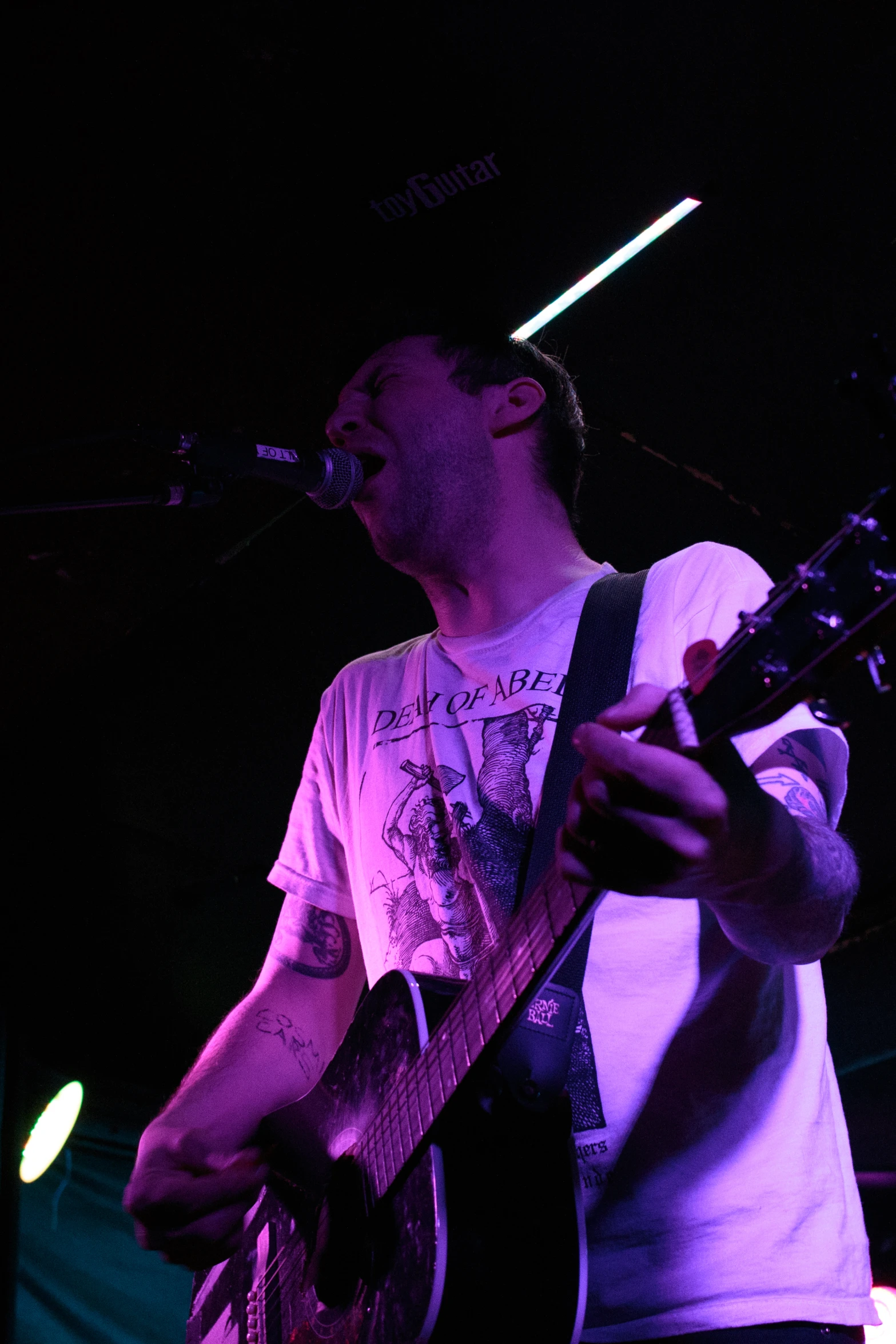 a person with a guitar standing in front of a microphone