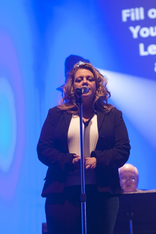 woman with microphone and speaker at podium with sound wave