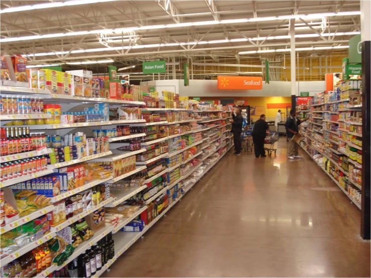 people in a grocery store aisle with shelves of food