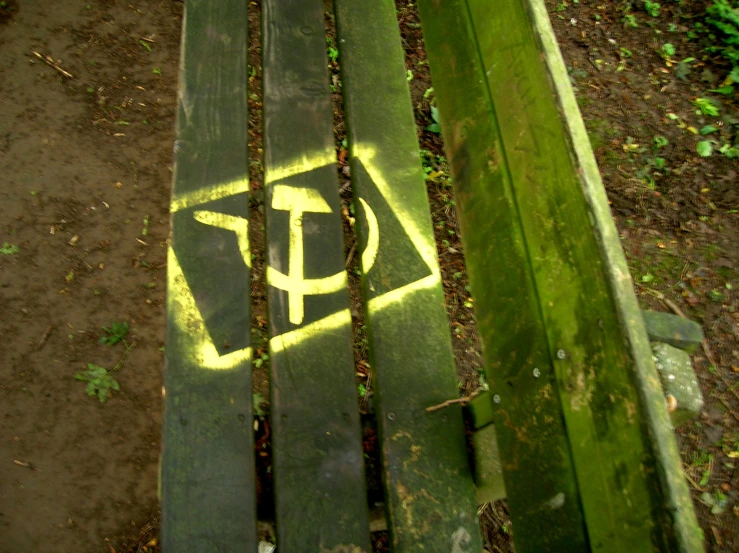 the bench is sitting on some grass near the woods