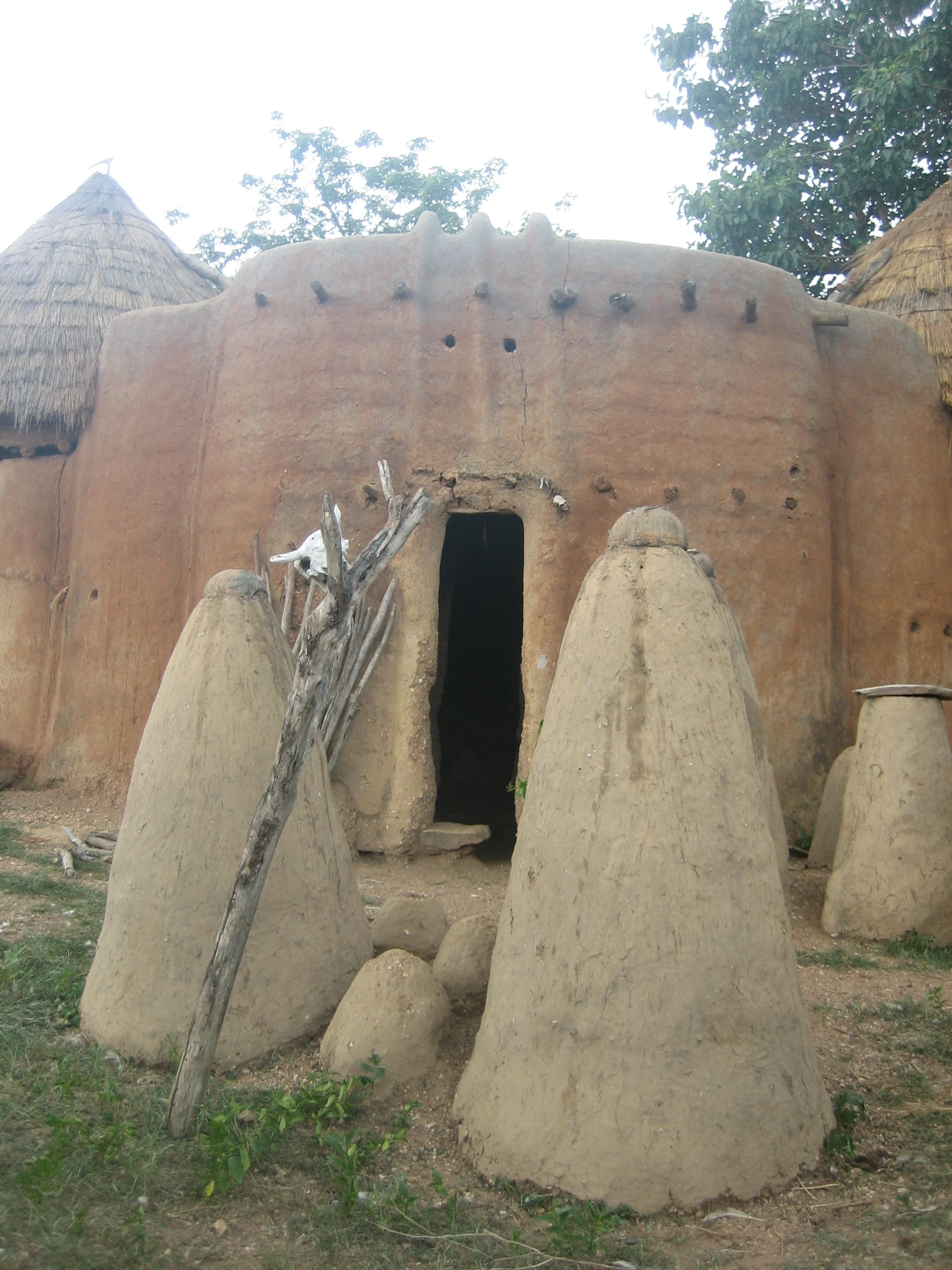 large mounds sit in a field beside a house