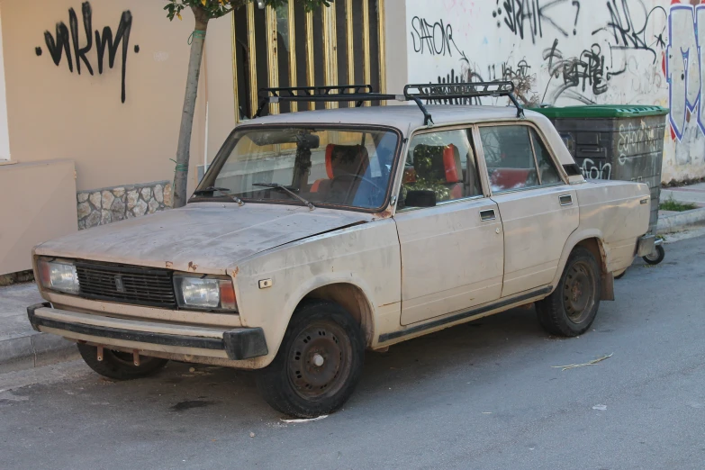 a truck is parked on the side of the street with graffiti behind it