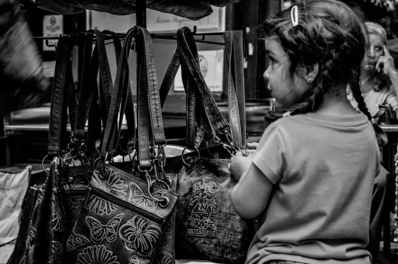 a little girl looking at a purse in a store