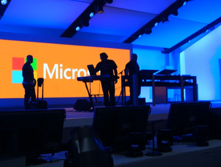 a group of people stand on stage to talk at a microphone