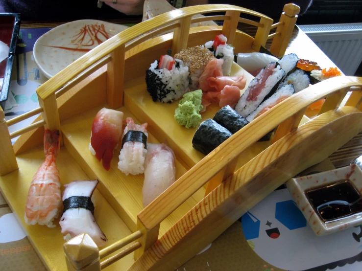 a close up of a small wooden boat filled with sushi