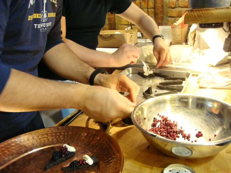 two people are preparing food in a bowl