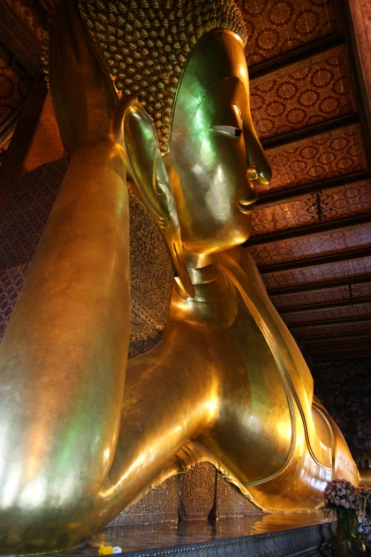 gold reclining sphinx statue inside an open temple
