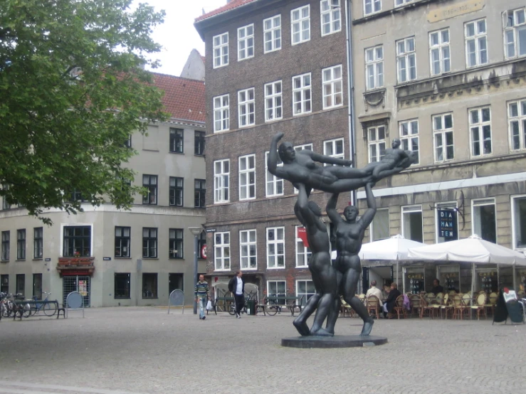 a group of people walking past some large buildings