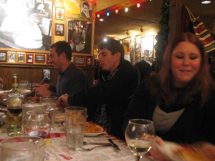 group of friends sitting at dinner table with food