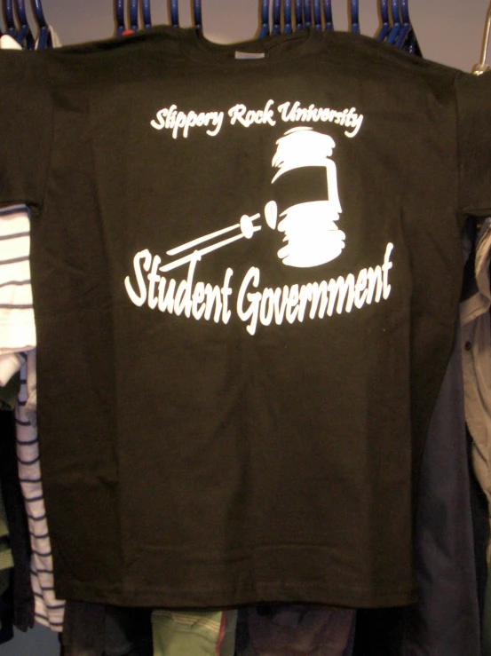 an unisex black student government t - shirt hanging on a rack