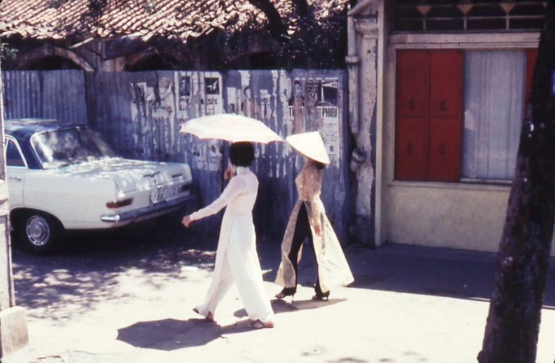 two people walking down the street holding an umbrella