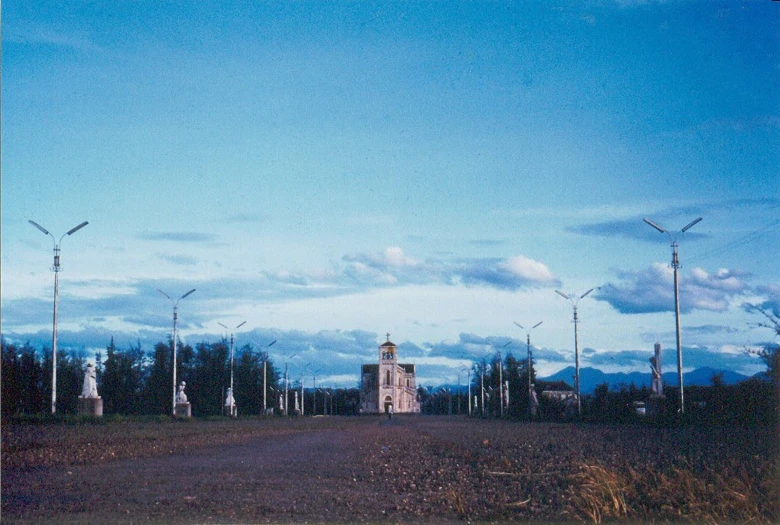 windmills are seen in the sky over a dirt road