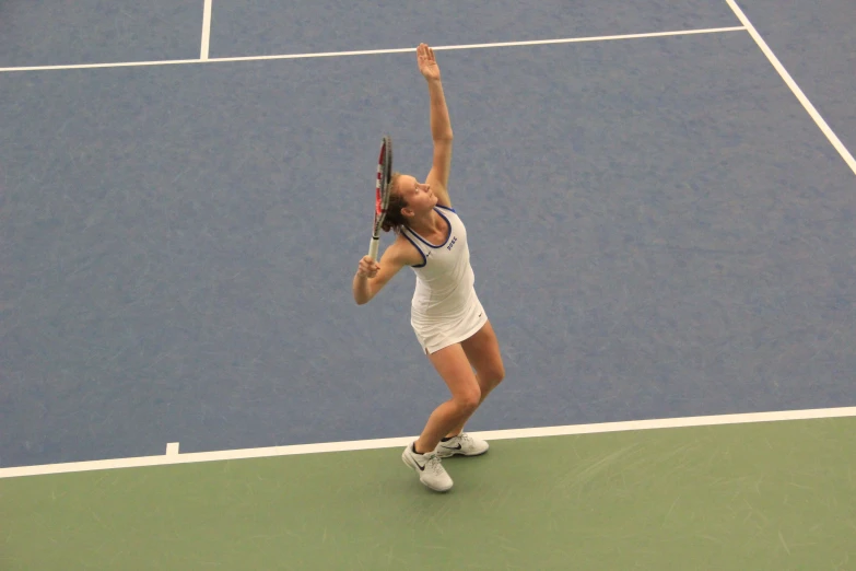 a woman serving a tennis ball on the tennis court