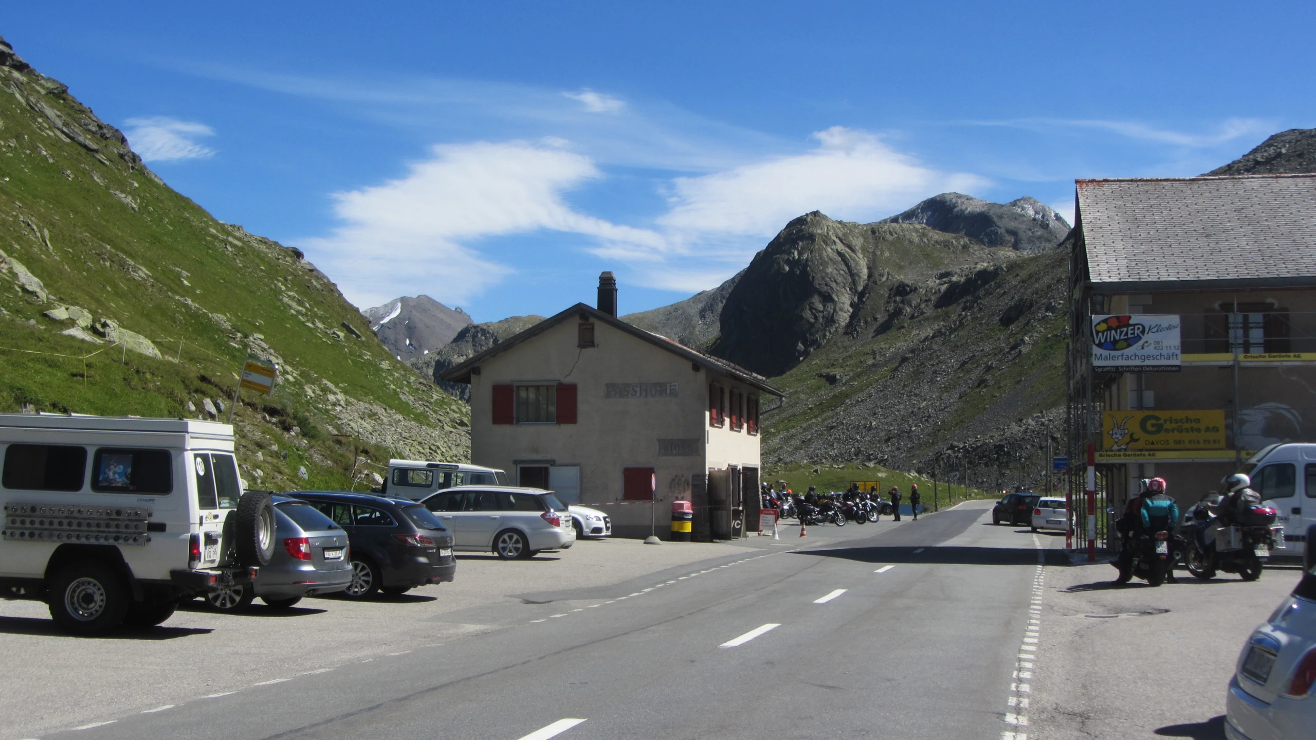 a town road with some vehicles parked along side of a street