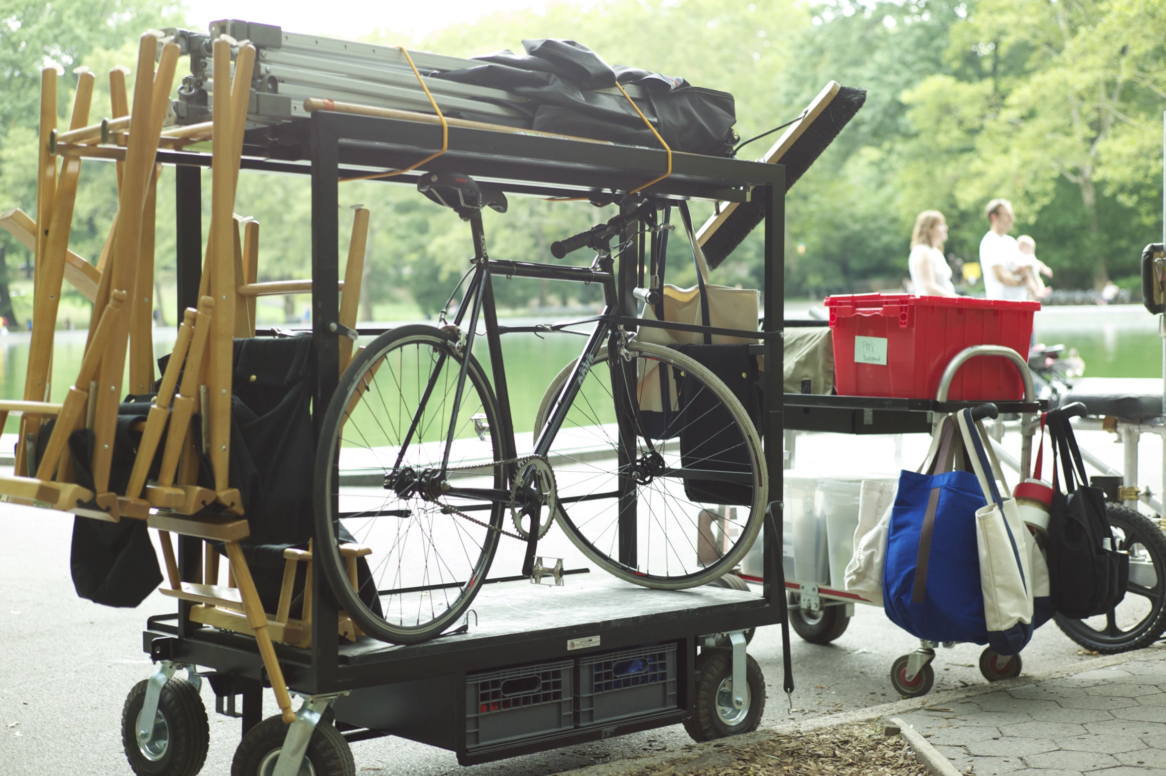 a small bike parked on a cart attached to a wooden bench