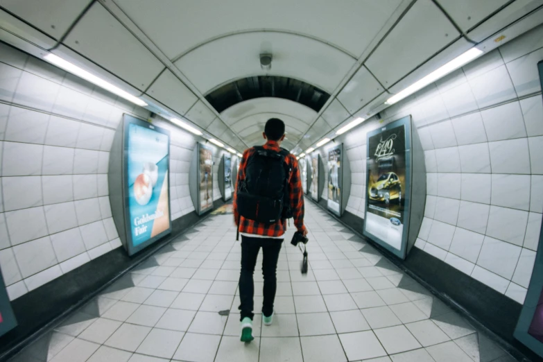 a man is walking through an empty subway station