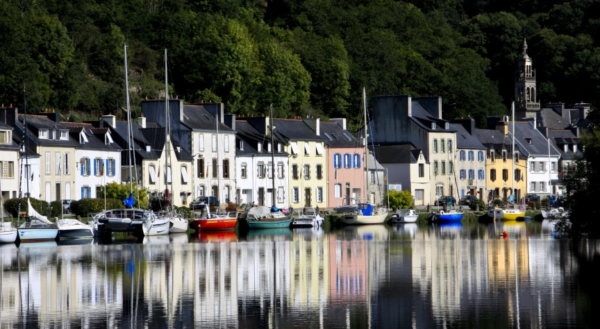 a row of buildings with different colored boats parked along the river