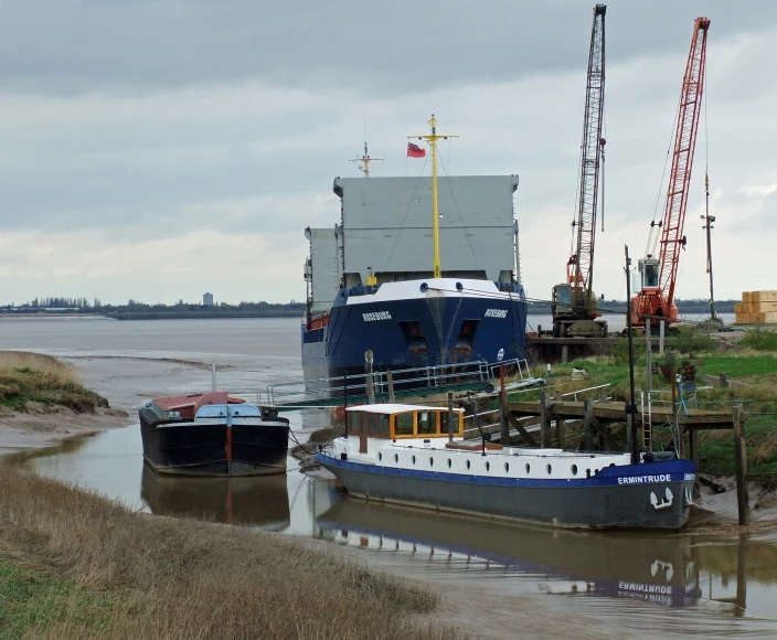 a large ship next to other docked boats on a body of water