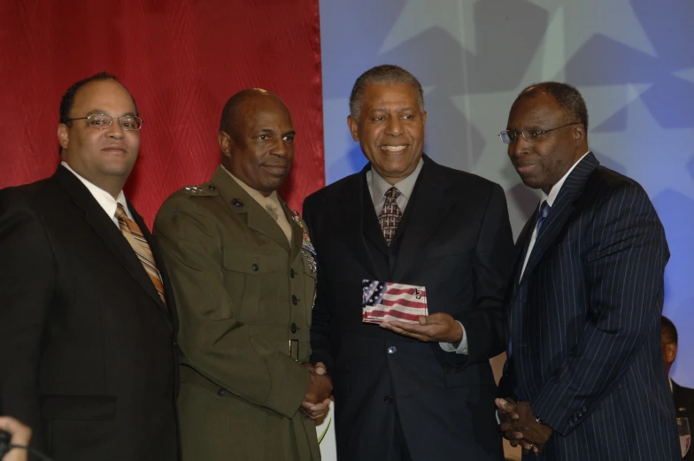 three men in suits and ties pose for the camera