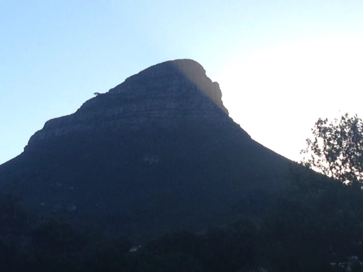 a tall mountain is seen against the sky