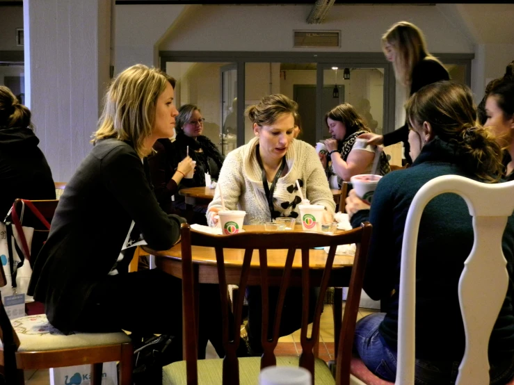 several women sitting around a table eating