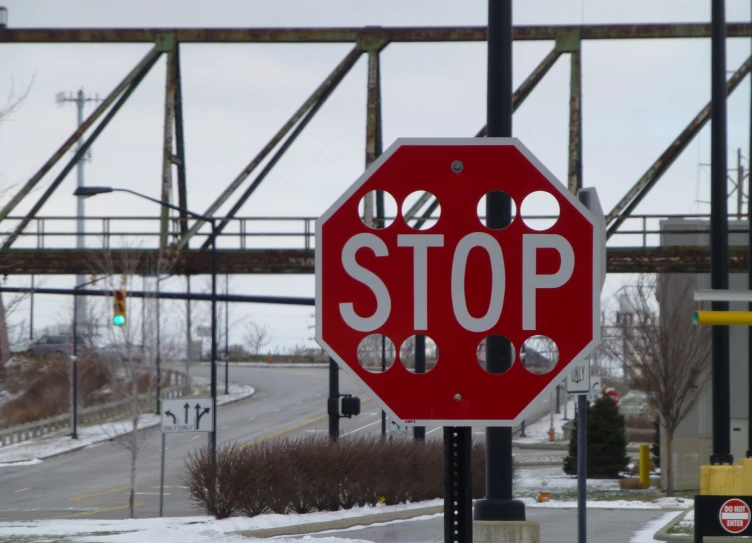 a red stop sign with holes cut out across it