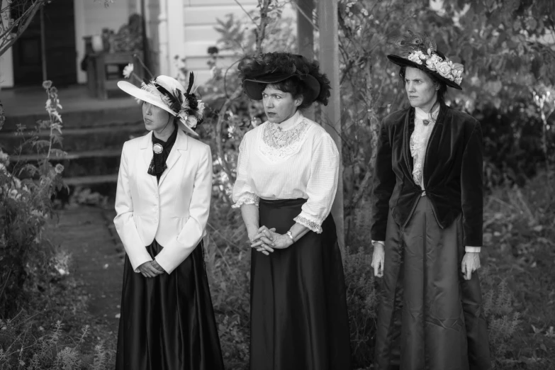 an old fashion po of four women wearing hats