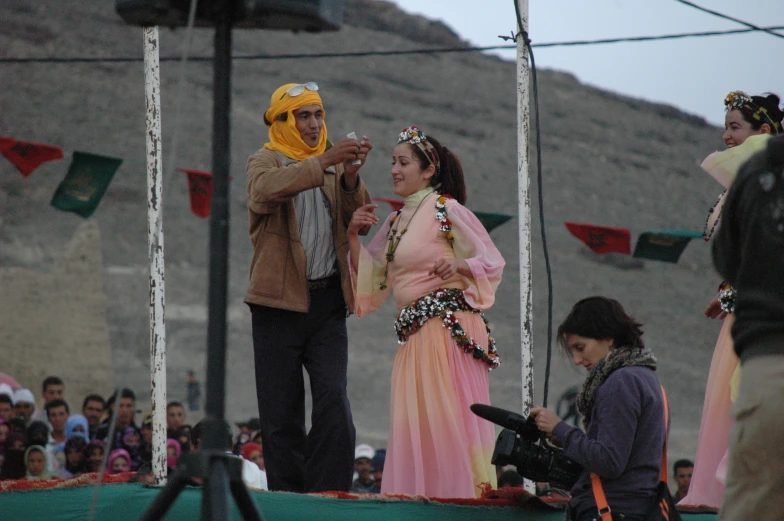 the man takes a picture of the woman wearing a hijab