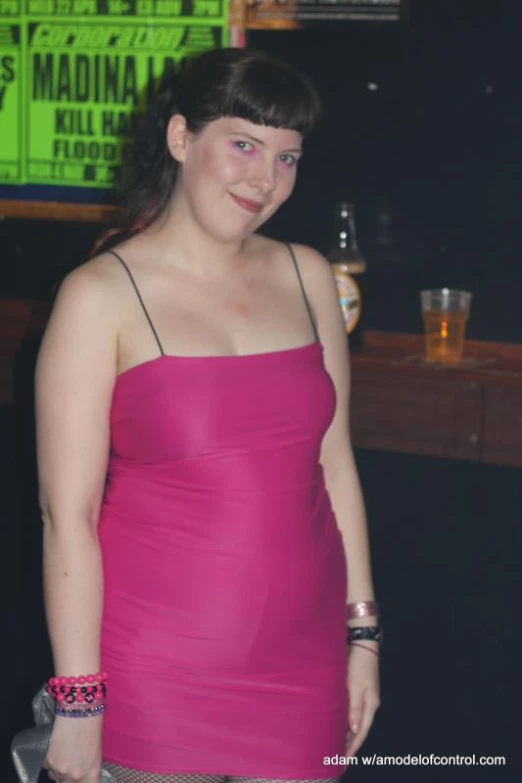 a woman wearing a dress and standing in front of a neon sign