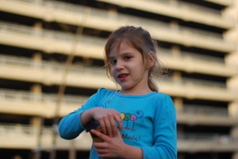 the girl is playing with her fingernails outside