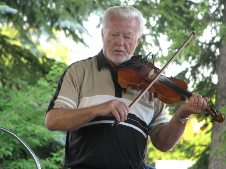 a man with an outfit and beard is playing the violin