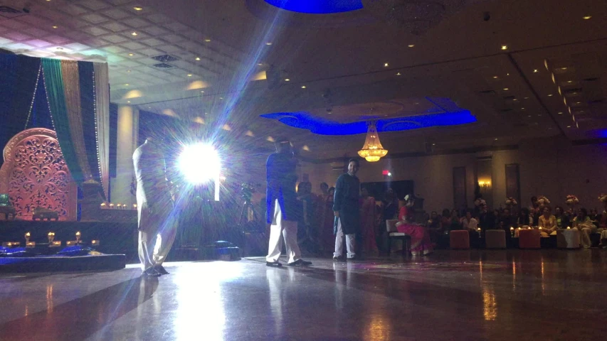 a couple dances under bright blue lights on their dance floor