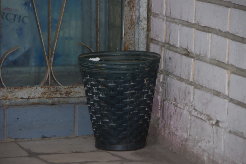 a trash can and window on a dirty floor