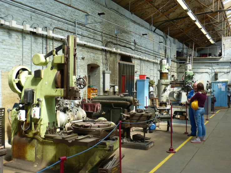 an industrial factory with workers looking at machinery