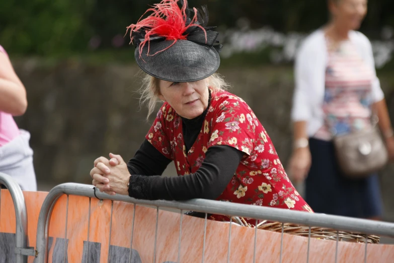 a woman in red sitting on the side of a rail