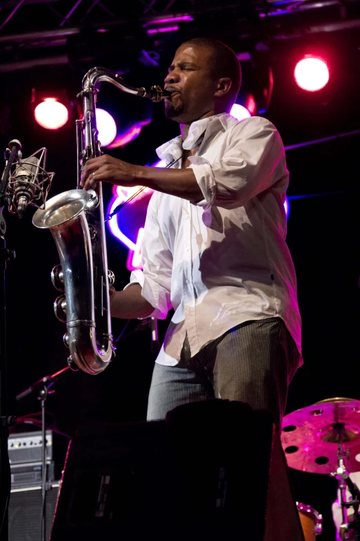 a man with an instrument in his hand and on stage