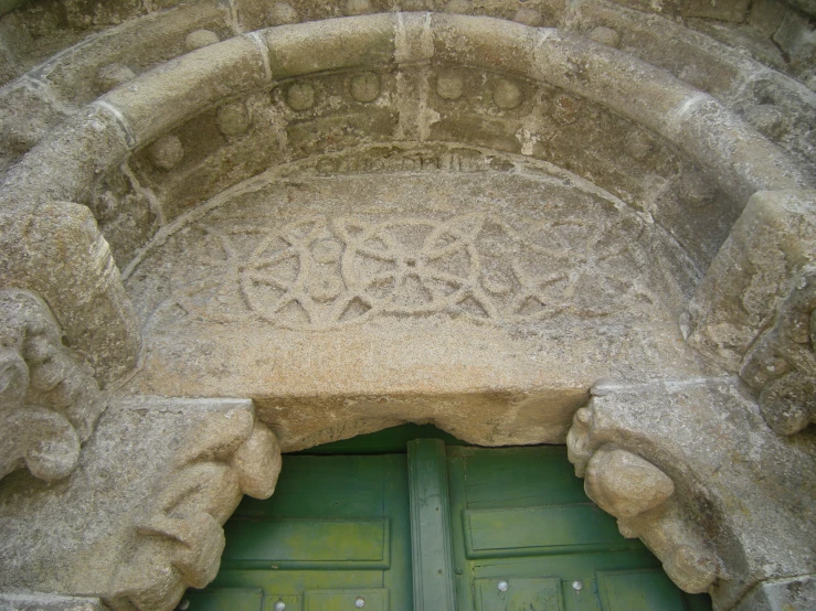 a carved doorway and a closed green door