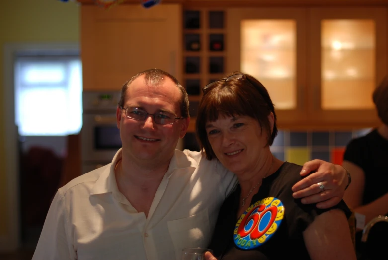 two people are posing together in the kitchen