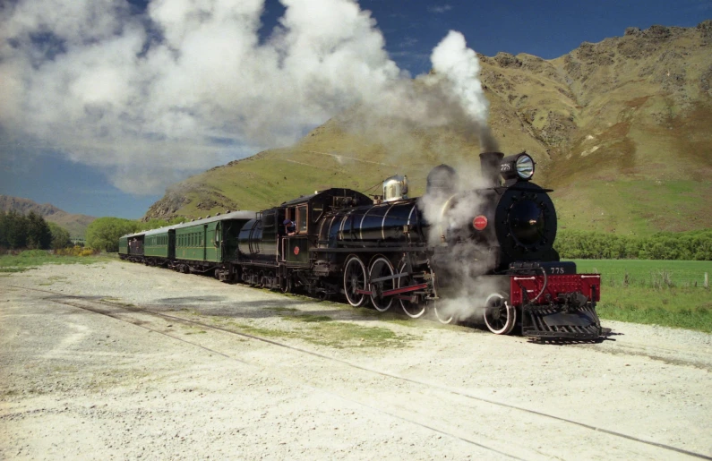 a black train has steam coming out of the engine