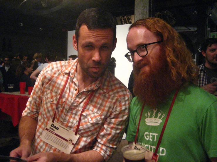 two bearded men standing next to each other at an event