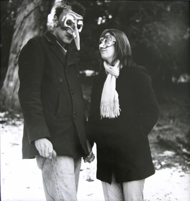 black and white pograph of man and woman wearing scary masks