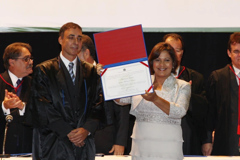 a woman holds up her award during a ceremony