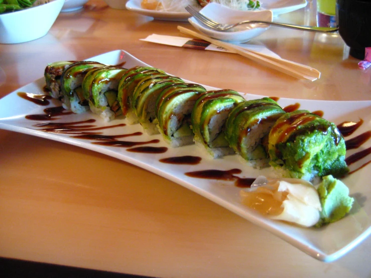 a plate with sushi and sauces on it