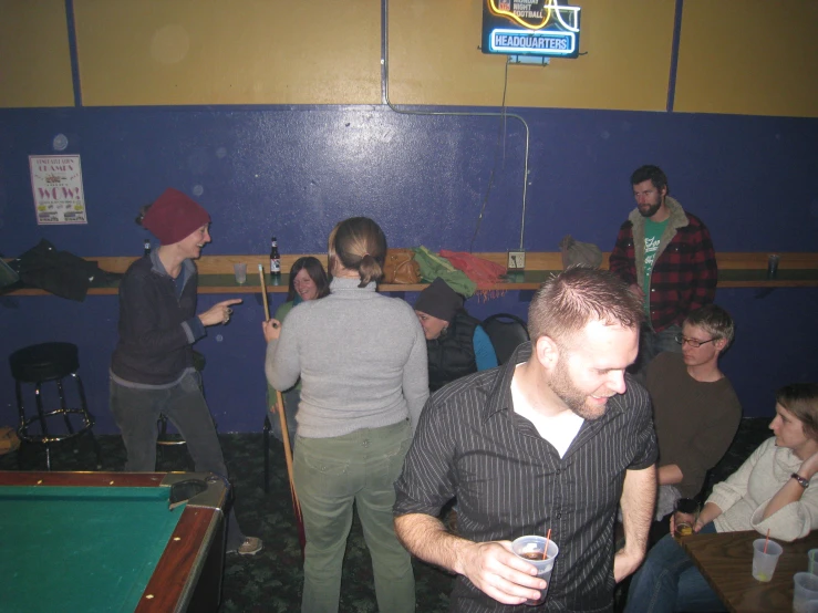 several people gathered together for a billiard game