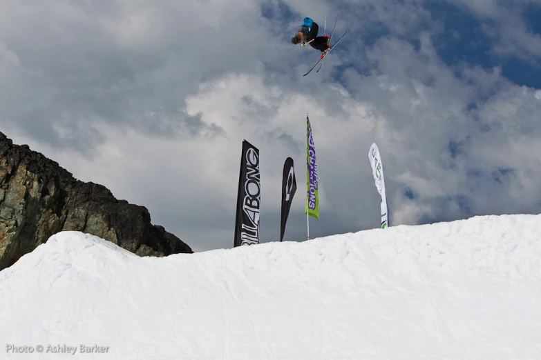 a snow boarder jumps off of the top of a mountain